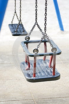 Empty swing on children playground in city.