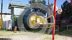 Empty swing on children playground. Playground without anyone. The town empty, loneliness, childhood