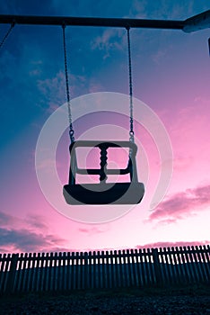 Empty swing on a colourful sky background, Bamford Derbyshire England.