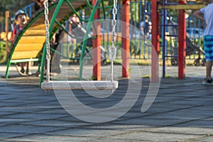 Empty swing at the playground. The concept of childhood and fun