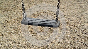 Empty swing seat swaying at playground in the park.