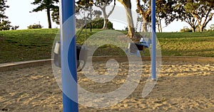 Empty swing set in the park. Children`s playground without players.