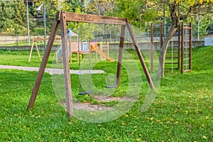 Empty swings at playground for child near children stairs slides equipment