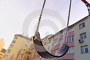 Empty swings on the playground in the courtyard of a residential building in Kyiv, Ukraine