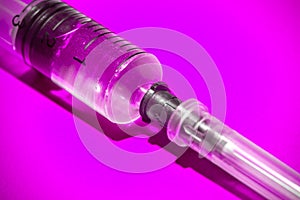 Empty syringe on pink background, close up. Theme drug addiction