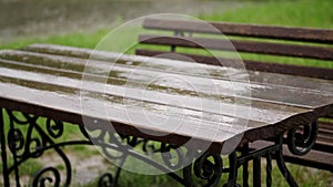 Empty table and the bench are drenched, wet under rain, on the playground, in the yard. a heavy rain, a thunderstorm, a