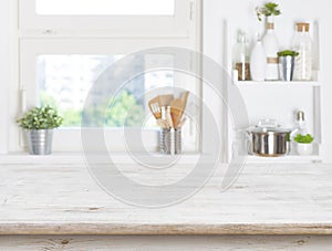 Empty table on blurred background of kitchen window and shelves