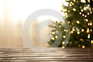 Empty table and blurred fir tree with yellow Christmas lights on background, bokeh effect