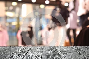 Empty table and blurred view of store with modern clothes