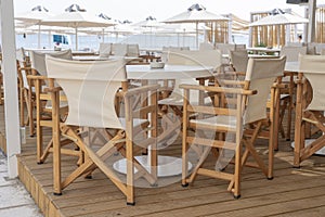 Empty table and chairs in restaurant, Greece. Beach cafe near sea, outdoors. Travel and vacation concept