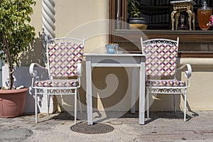 Empty table and chairs in restaurant, Greece. Beach cafe near sea, outdoors. Travel and vacation concept