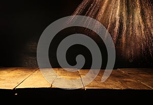 Empty table in front of black and gold glitter lights background