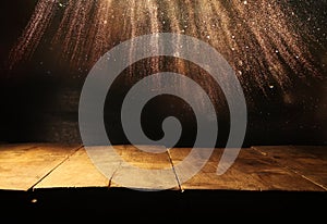 Empty table in front of black and gold glitter lights background