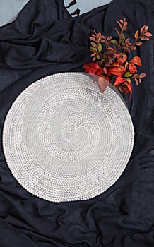 Empty table mat on navy cloth with red leaves