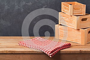 Empty table with tablecloth and wooden boxes over dark blackboard background for product montage