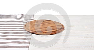 Empty tablecloth on wood table and pizza cutting board isolated on white background. Selective focus. Place for food. Top view.