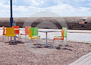 Empty tables and beautiful colourful plastic chairs in a street