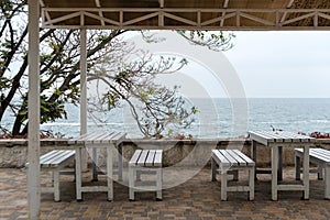 Empty tables and chairs of a restaurant on a terrace overlooking the sea. Cafe with sea view. Nice place to eat with seaview.