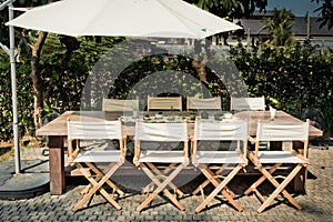 Empty tables, chairs and umbrellas in the garden for BBQ Party