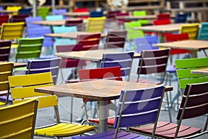 Empty tables and coloured chairs in a street