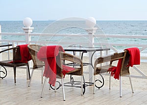 Empty tables at hotel restaraunt with red plaids on the beach