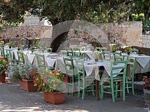 Empty Tables Set for Outdoor Lunch under an Olive Tree in a Tuscan Village in Italy