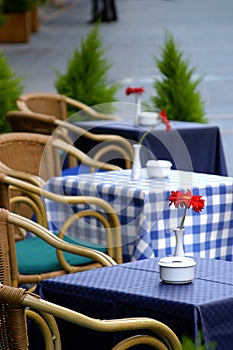 Empty tables on the street with roses on them outside a cafe bar or restaurant . photo