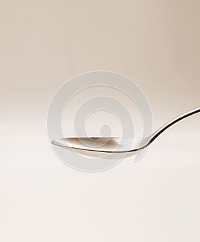 Empty tablespoon of metal on sepia background photo