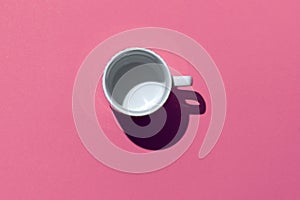 Empty tea cup on pink background. Coffee mug from above. Minimal concept Hard deep shadow. Flat lay, top view