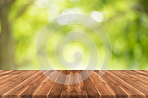 Empty teak wood table top on nature green blurred background,space for montage show products