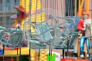 Empty teal blue chairs of chair swing ride at funfair park