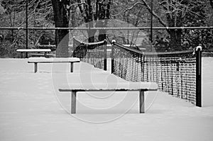 Empty tennis court covered with snow in a park