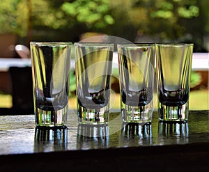 Empty tequila vodka shot glasses on outdoor bar counter