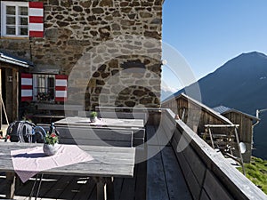 Empty terrace of Nurnberger Hutte mountain hut at valley with sharp mountain peaks at Stubai hiking trail, Stubai photo