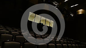 Empty theater hall with dark fabric seats. Media. Camera flight through a concert venue with a stage and lighting