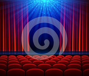 Empty theater stage with red opening curtain, spotlight and seats
