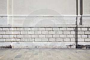 Empty tiled stone sidewalk and white ancient wall photo