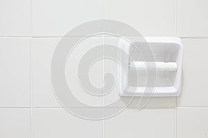 Empty toilet paper roll mounted on a tiled wall