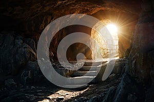 Empty tomb with stone rocky cave and light rays bursting from within. Easter resurrection of Jesus Christ. Christianity