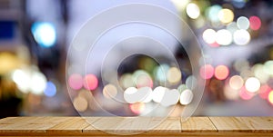 Empty top wood table and blur city night background.