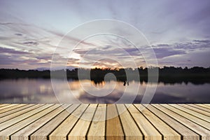 Empty top wooden decking and sunset moment at little lake background. Can use for product display