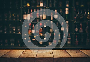 Empty the top of wooden table with blurred counter bar and bottles