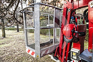 An empty tracked basket for gardeners with helmet. Mobile aerial work platform