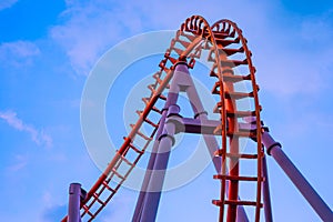 Empty tram rails or loop Roller Coaster with blue sky in amusement park