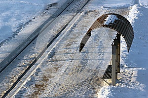 Empty tram stop with rails at winter evening