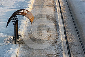 Empty tram stop with rails at winter evening