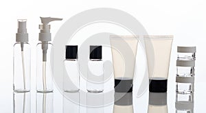 Empty transparent cosmetics bottles and jars on white background