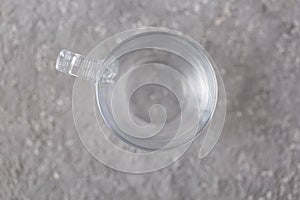Empty transparent cup on gray background