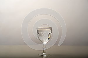 An empty transparent glass cup on a glass surface