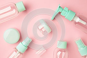 Empty travel cosmetic bottles on pink background. Minimalist bodycare beauty products for vacation or journey. Top view. Copyspace